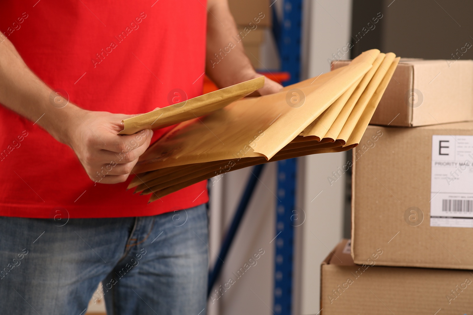 Photo of Post office worker with adhesive paper bags indoors, closeup