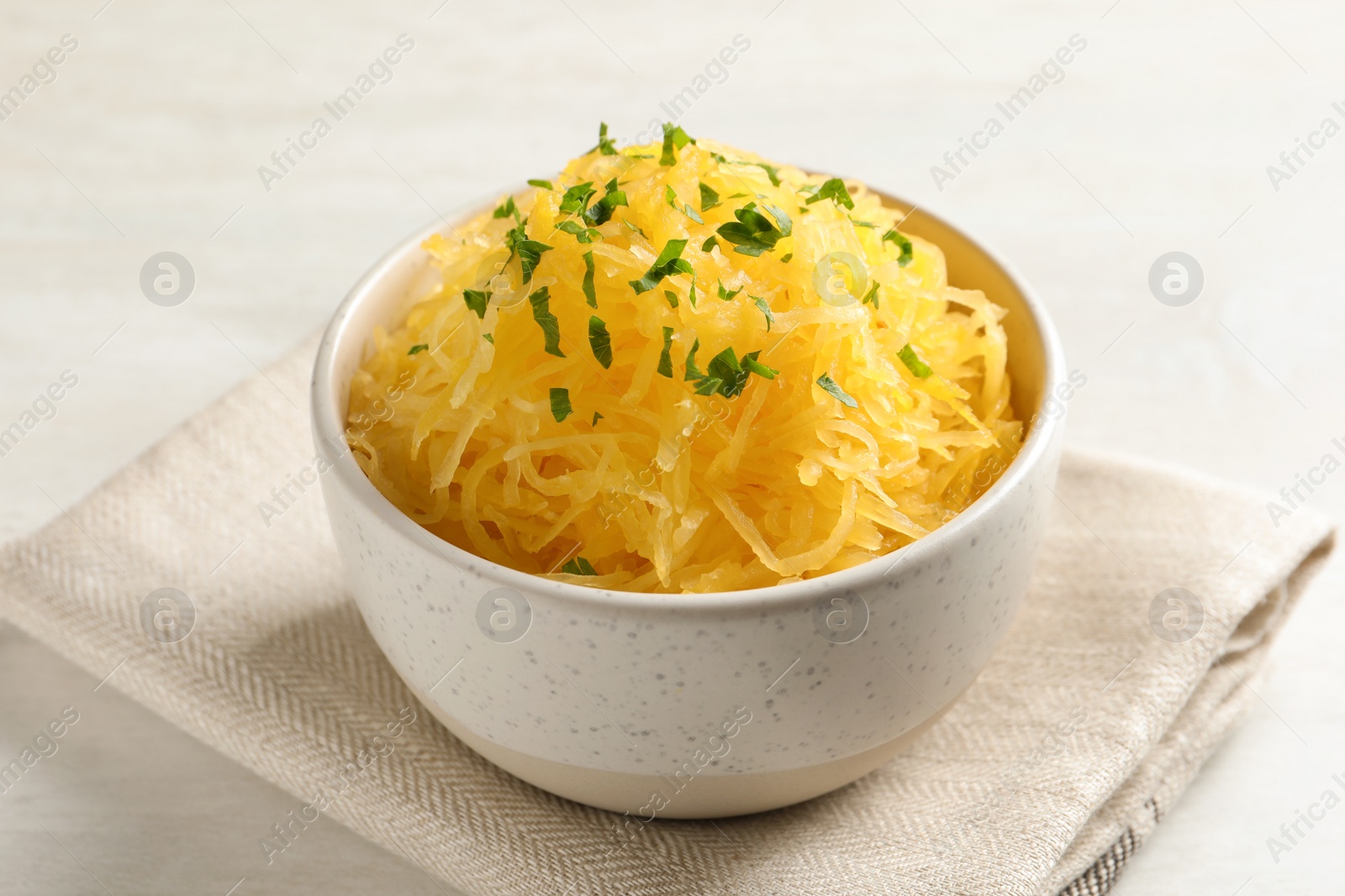 Photo of Bowl with cooked spaghetti squash on white table