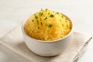 Bowl with cooked spaghetti squash on white table