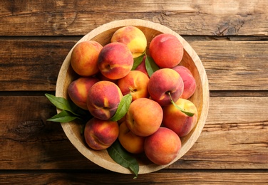 Photo of Fresh sweet peaches on wooden table, top view