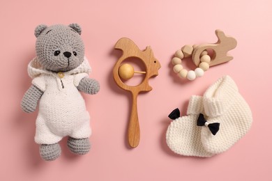 Photo of Baby accessories. Different toys and booties on pink background, flat lay