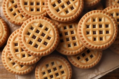 Tasty sandwich cookies with cream on wooden table. flat lay