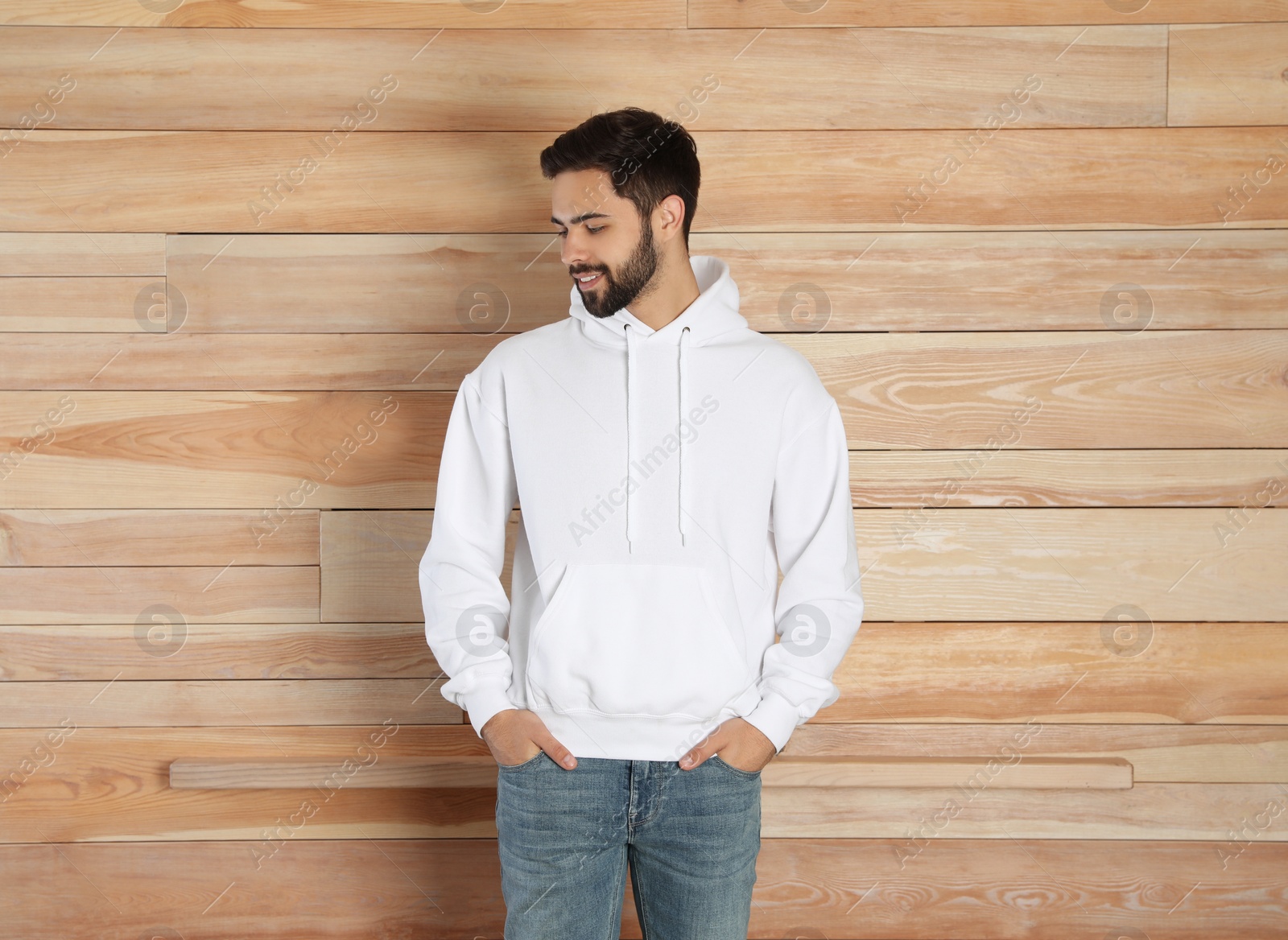 Photo of Portrait of young man in sweater at wooden wall. Mock up for design