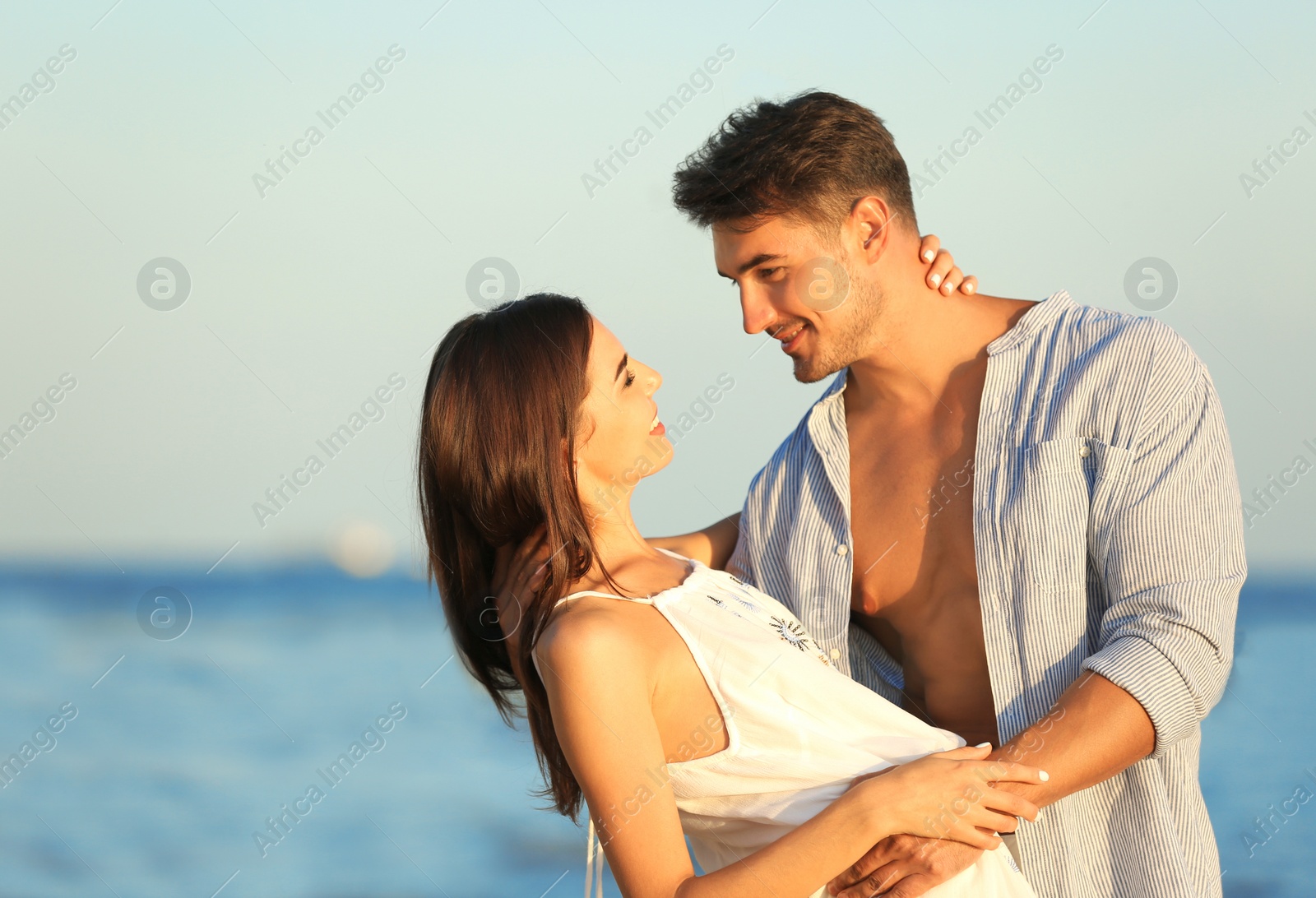 Photo of Happy young couple posing near sea on beach