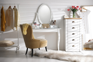 Photo of Stylish room interior with elegant dressing table, mirror and comfortable chair