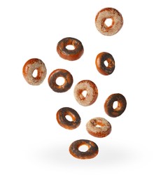 Image of Many fresh bagels with poppy and sesame seeds falling on white background
