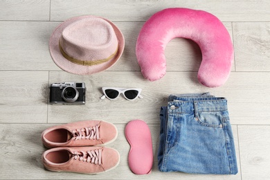 Photo of Flat lay composition with travel pillow and tourist stuff on wooden floor