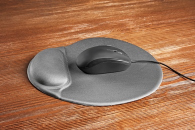 Photo of Blank pad and computer mouse on wooden background