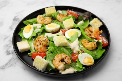 Photo of Delicious Caesar salad with shrimps on white marble table, closeup