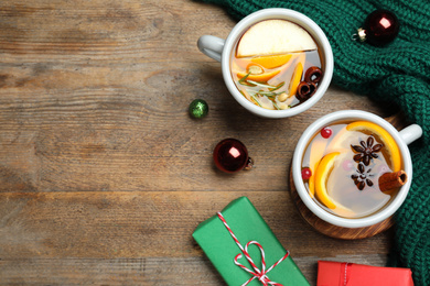 Photo of Aromatic mulled wine on wooden table, flat lay. Space for text