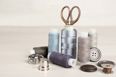 Photo of Composition with different sewing items on light beige table