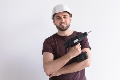 Photo of Young working man with electric screwdriver on white background
