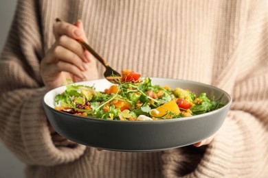 Photo of Woman eating delicious salad with lentils and vegetables, closeup