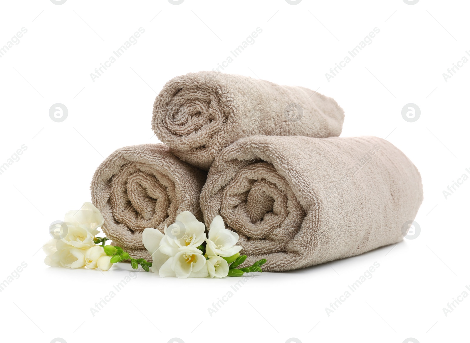 Photo of Clean rolled towels with flowers on white background