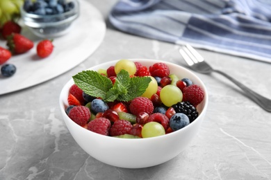 Photo of Fresh tasty fruit salad on grey marble table