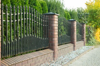 Beautiful brick fence with iron railing outdoors