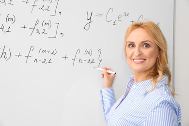 Photo of Professor writing down math equation on whiteboard