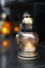 Photo of Grave light on granite surface at cemetery, closeup