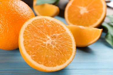 Photo of Delicious ripe oranges on light blue wooden table, closeup