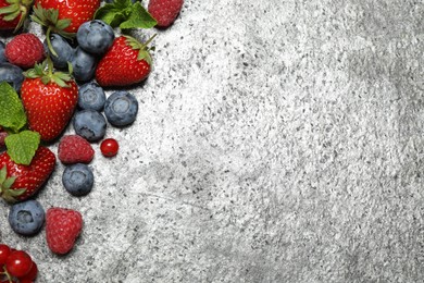 Photo of Different fresh berries on grey background, flat lay. Space for text