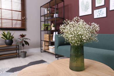 Photo of Beautiful gypsophila flowers in vase on table indoors. Space for text