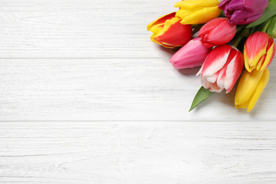 Photo of Beautiful spring tulips on white wooden table, flat lay. Space for text
