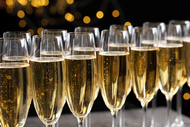 Photo of Many glasses of champagne on blurred background, closeup