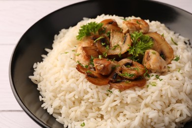Photo of Delicious rice with parsley and mushrooms on plate, closeup