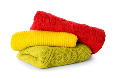 Photo of Stack of different warm sweaters isolated on white