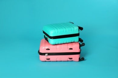 Photo of Stylish carry on suitcases on color background