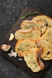 Photo of Tasty baguette with garlic, dill and rosemary on grey textured table, top view