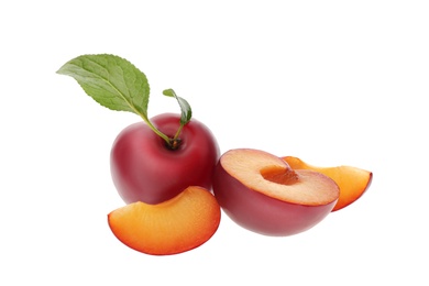 Photo of Whole and cut ripe plums with green leaves isolated on white
