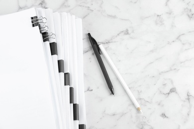 Photo of Stack of documents with binder clips on marble table, top view