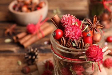 Photo of Aromatic potpourri in glass jar on table, closeup. Space for text