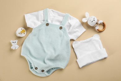 Photo of Flat lay composition with baby clothes and accessories beige background