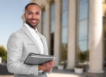 Image of Lawyer, consultant, business owner. Confident man with file folders smiling outdoors, space for text