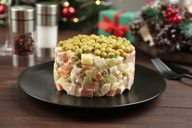 Photo of Traditional russian salad Olivier served on wooden table