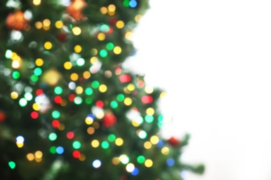 Photo of Blurred view of fir tree with glowing Christmas lights indoors. Festive mood