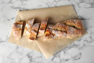 Photo of Tasty bread on marble background, top view