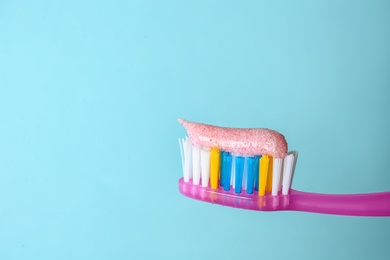 Toothbrush with paste on color background, closeup