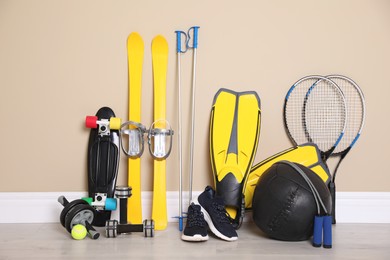 Photo of Different sports equipment near beige wall indoors