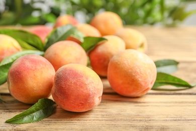 Photo of Fresh sweet ripe peaches on wooden table