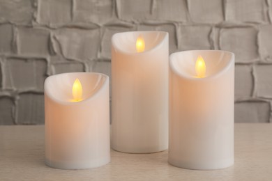 Photo of Decorative LED candles on white wooden table