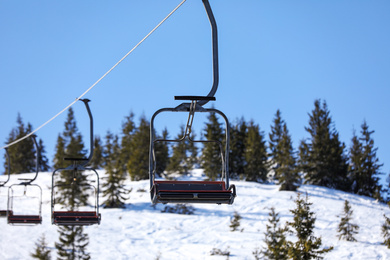 Photo of Empty chairlift at mountain ski resort. Winter vacation