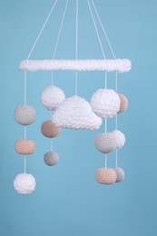 Photo of Cute baby crib mobile on light blue background