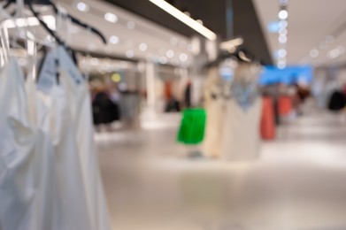 Photo of Blurred view of modern boutique interior with stylish clothes