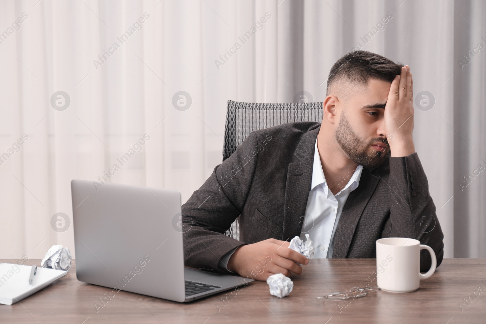 Photo of Sad businessman sitting at table in office