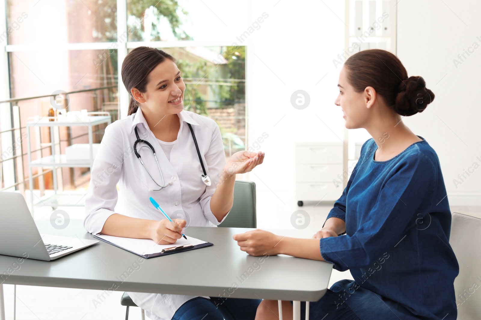 Photo of Young doctor speaking to patient in hospital