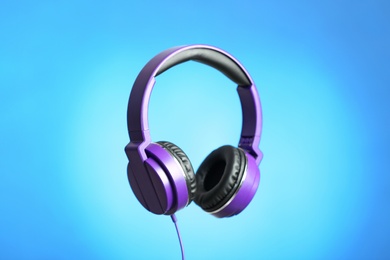 Photo of Stylish headphones with pads on color background