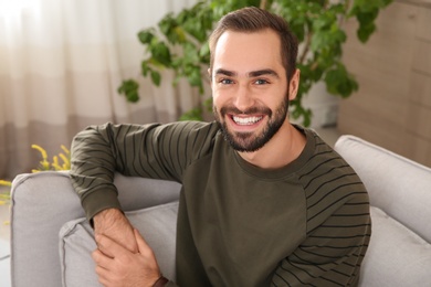 Photo of Portrait of young man laughing at home